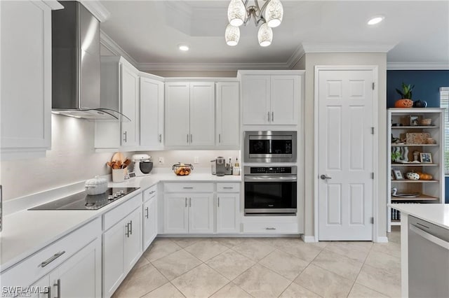 kitchen with wall chimney exhaust hood, white cabinetry, ornamental molding, and appliances with stainless steel finishes