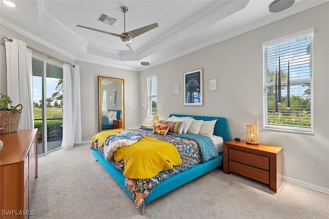 carpeted bedroom with access to outside, ceiling fan, a tray ceiling, and ornamental molding