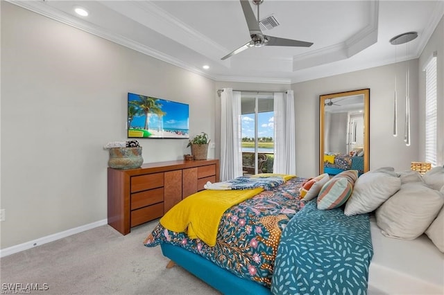 bedroom with light carpet, a tray ceiling, ceiling fan, and ornamental molding