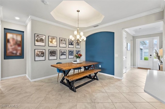 tiled dining room with a tray ceiling, crown molding, and a notable chandelier