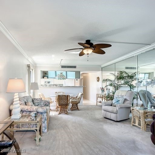 living room with ceiling fan, a healthy amount of sunlight, ornamental molding, and light carpet