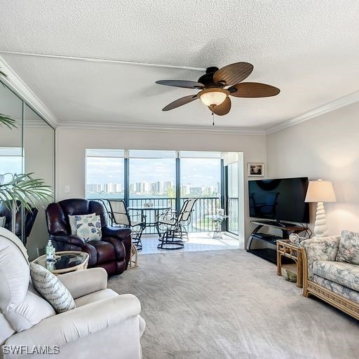 carpeted living room with a textured ceiling, ceiling fan, and crown molding