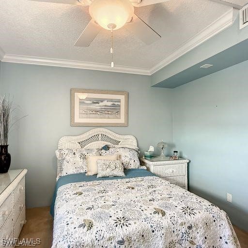 bedroom featuring carpet flooring, a textured ceiling, ceiling fan, and crown molding