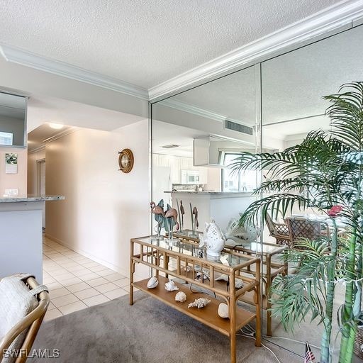 tiled dining space featuring ornamental molding and a textured ceiling