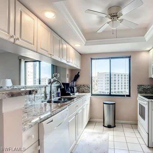 kitchen featuring white cabinetry, white appliances, sink, and a tray ceiling