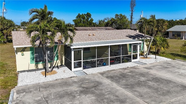 rear view of property with a sunroom and a yard