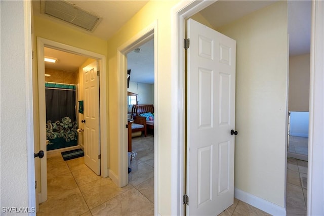 hall featuring light tile patterned flooring