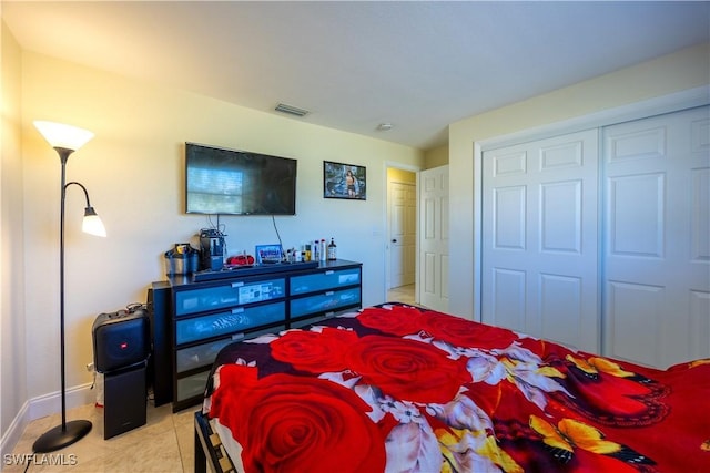 bedroom with light tile patterned floors and a closet