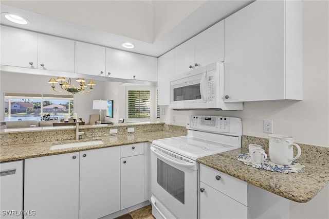 kitchen featuring plenty of natural light, white cabinetry, sink, and white appliances