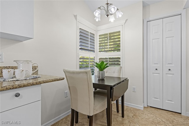 tiled dining room with an inviting chandelier