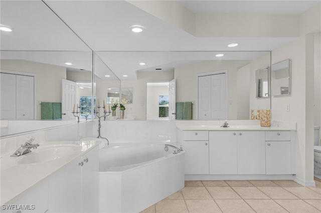 bathroom featuring tile patterned flooring, vanity, toilet, and a washtub