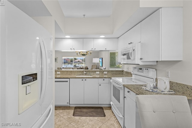 kitchen with light stone counters, white appliances, sink, light tile patterned floors, and white cabinets