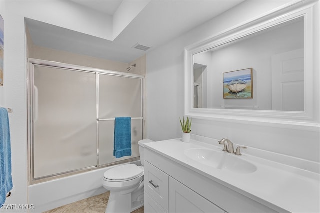 full bathroom with combined bath / shower with glass door, vanity, toilet, and tile patterned flooring