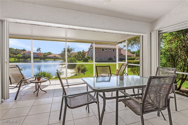 sunroom featuring a water view