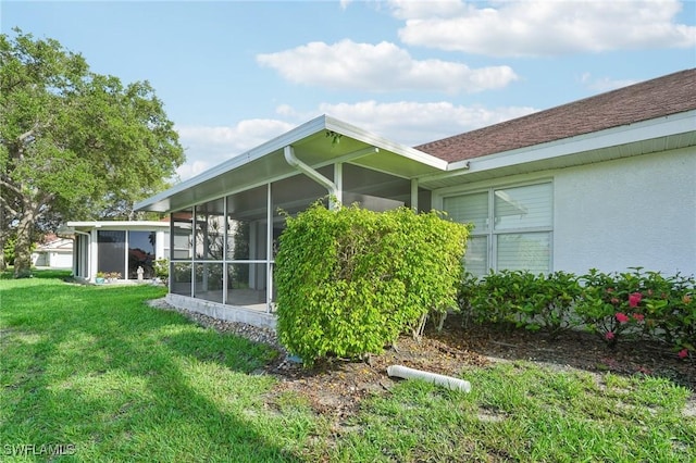 view of property exterior with a sunroom and a lawn