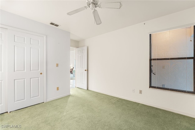 unfurnished bedroom featuring ceiling fan, a closet, and light carpet