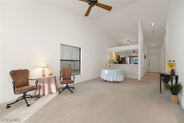 living area featuring ceiling fan, light colored carpet, and vaulted ceiling