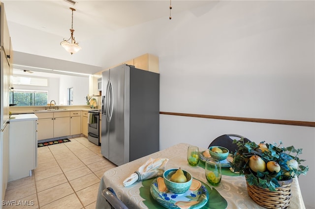 kitchen featuring light tile patterned floors, stainless steel appliances, hanging light fixtures, and sink