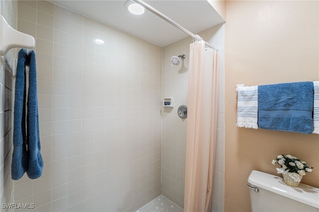 bathroom with a shower with curtain and toilet