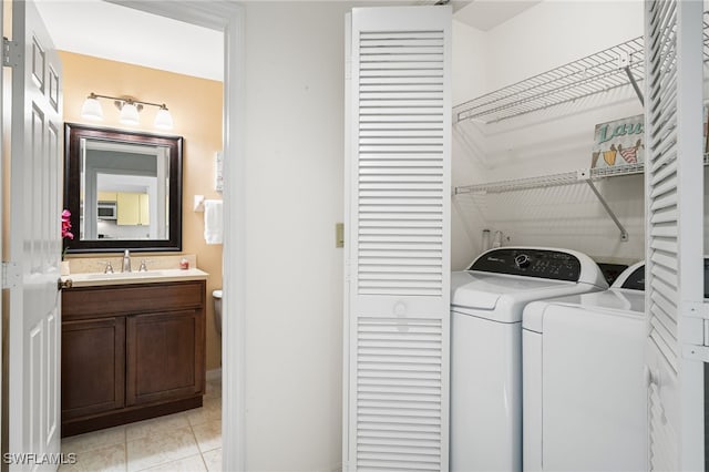 laundry area with sink, light tile patterned floors, and independent washer and dryer