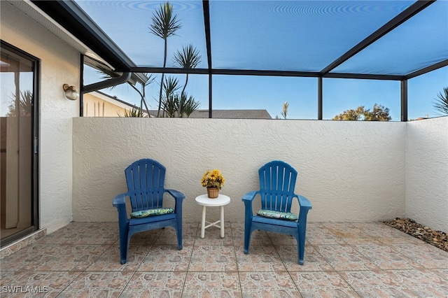 view of patio featuring glass enclosure