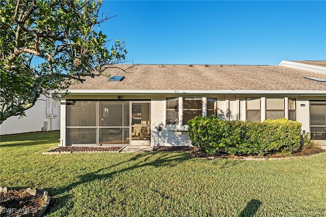 back of property featuring a lawn and a sunroom