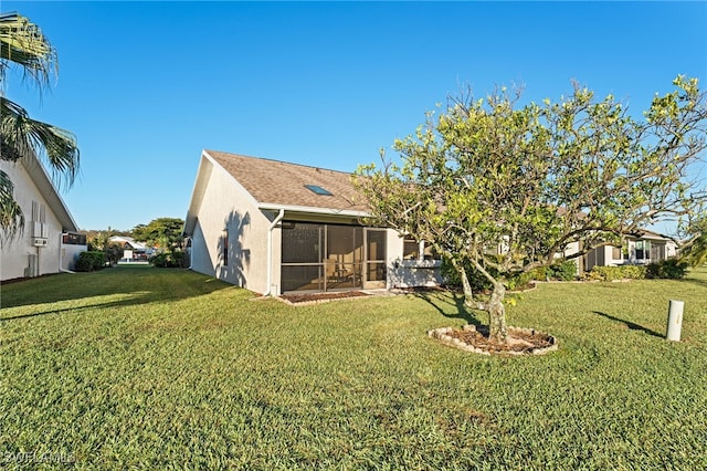 rear view of property with a lawn and a sunroom