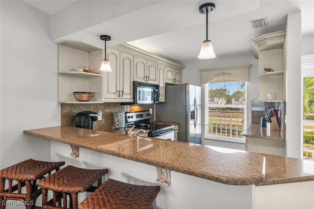 kitchen featuring white cabinets, decorative backsplash, kitchen peninsula, and stainless steel appliances