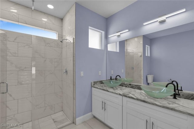 bathroom featuring tile patterned flooring, vanity, and walk in shower