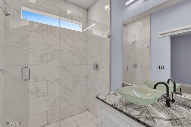 bathroom with tile patterned flooring, vanity, and walk in shower