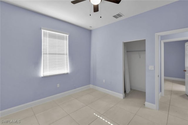 unfurnished bedroom with ceiling fan, a closet, and light tile patterned floors