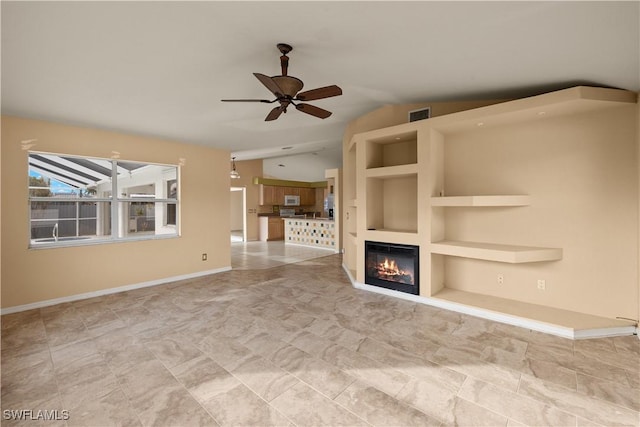 unfurnished living room with vaulted ceiling, built in features, and ceiling fan