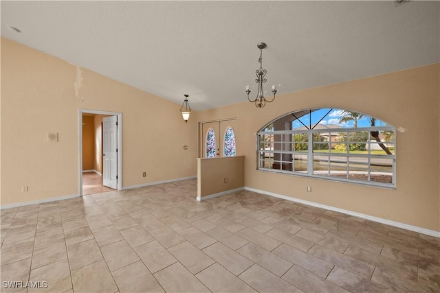 empty room with a notable chandelier, lofted ceiling, and light tile patterned floors