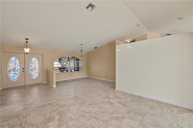 foyer entrance featuring vaulted ceiling, a notable chandelier, and french doors