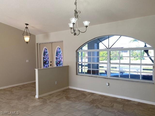 empty room featuring an inviting chandelier