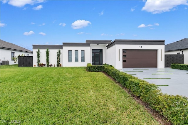 modern home featuring central AC unit, a garage, and a front yard