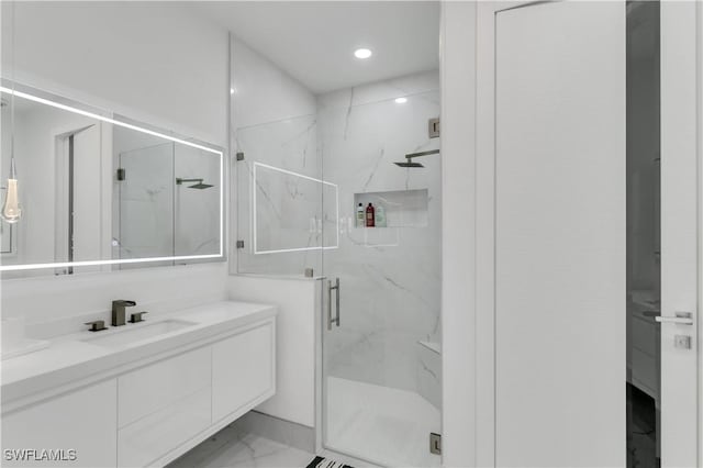 bathroom with a shower with door and vanity