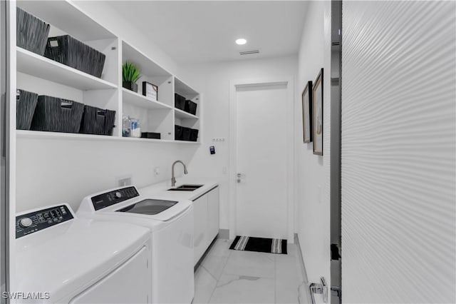 laundry area featuring cabinets, sink, and washer and dryer