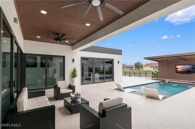 view of swimming pool with ceiling fan, an outdoor living space, and a patio