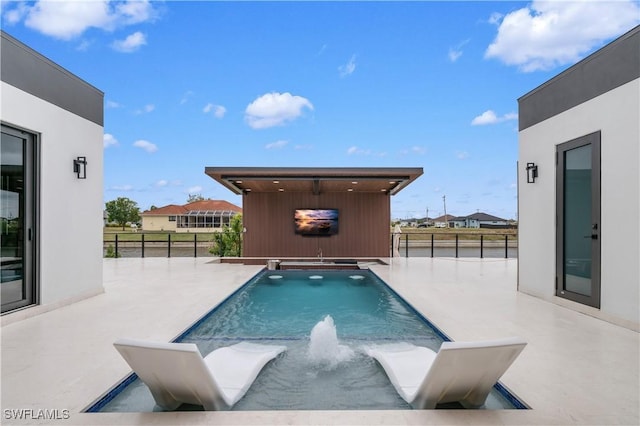 view of pool featuring pool water feature and a patio