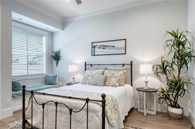 bedroom featuring ceiling fan, hardwood / wood-style floors, and crown molding