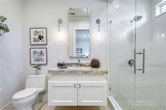 bathroom featuring hardwood / wood-style floors, vanity, toilet, and a shower with shower door