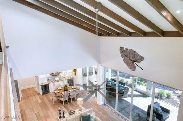 unfurnished living room featuring lofted ceiling with beams and light wood-type flooring