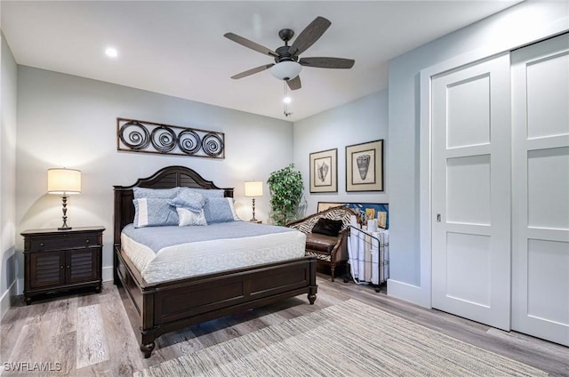 bedroom with ceiling fan, a closet, and hardwood / wood-style flooring