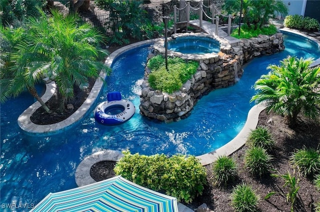 view of swimming pool featuring an in ground hot tub