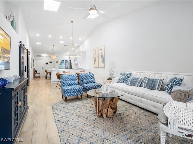 living room featuring light hardwood / wood-style floors, vaulted ceiling, and ceiling fan