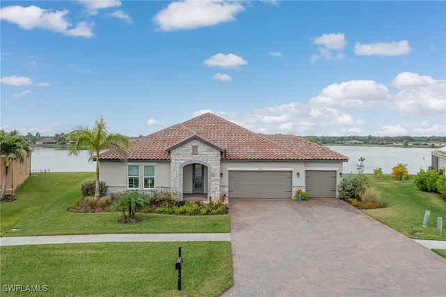 view of front of home featuring a garage, a water view, and a front lawn