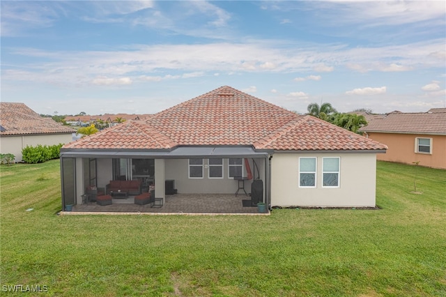 back of property with glass enclosure, a yard, and a patio