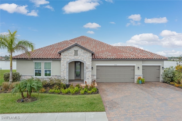 mediterranean / spanish-style home with a front lawn and a garage