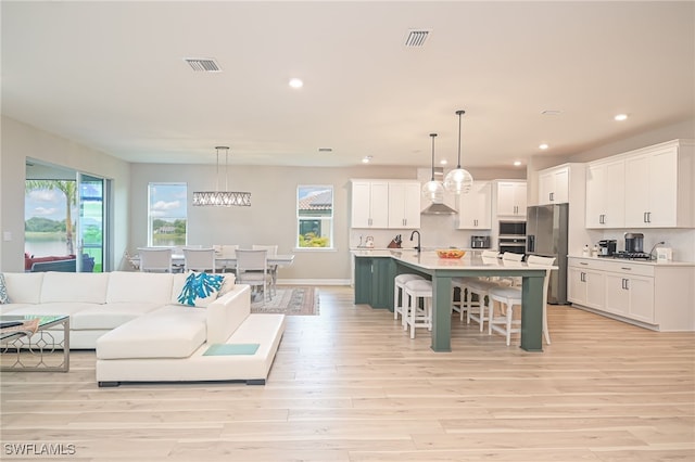 kitchen with white cabinets, decorative light fixtures, and a wealth of natural light